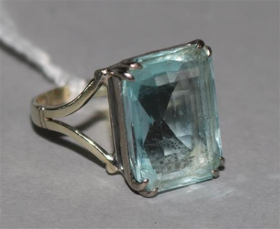 An aquamarine dress ring, the emerald-cut stone in white metal setting, size K.